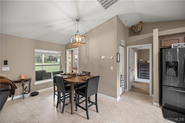 tiled dining area featuring a chandelier and lofted ceiling