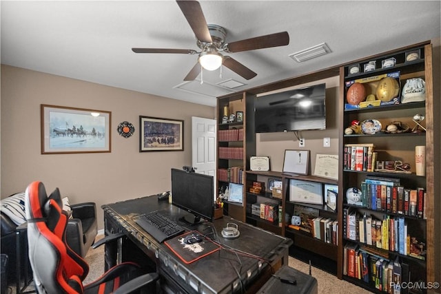 carpeted office space featuring ceiling fan