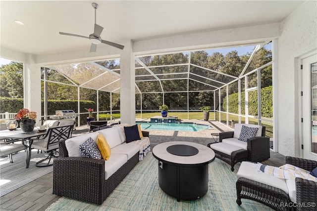 view of patio featuring glass enclosure and an outdoor living space with a fire pit