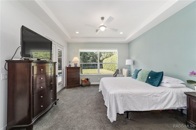 bedroom featuring ceiling fan, a raised ceiling, and light carpet