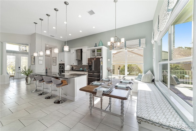 kitchen with white cabinets, pendant lighting, a breakfast bar area, and high quality fridge