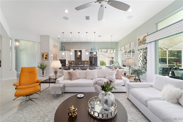 living room featuring ceiling fan with notable chandelier and light tile patterned floors