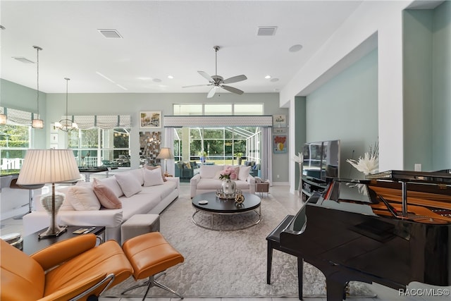 living room with ceiling fan with notable chandelier