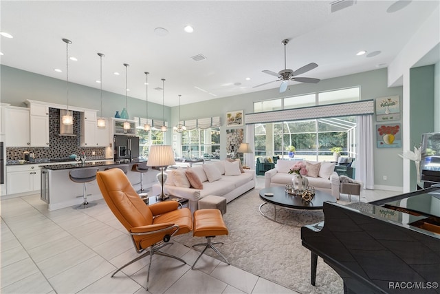 tiled living room with a wealth of natural light and ceiling fan