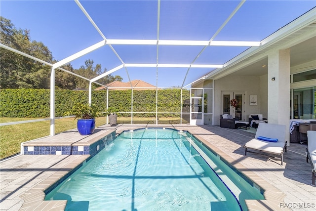 view of pool with a lanai, a patio area, and pool water feature