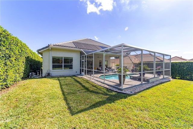 back of house with a lawn, glass enclosure, and a fenced in pool