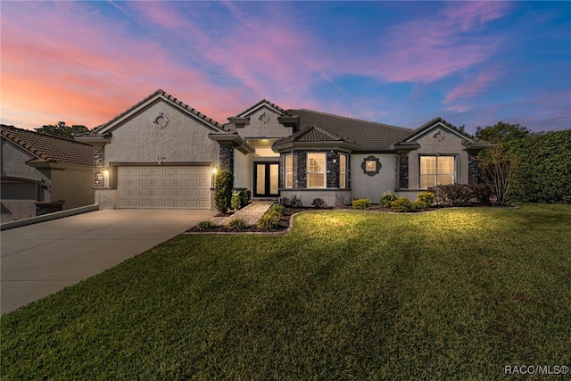 view of front of house with a garage and a yard