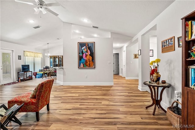 interior space with lofted ceiling, visible vents, baseboards, and light wood-style flooring
