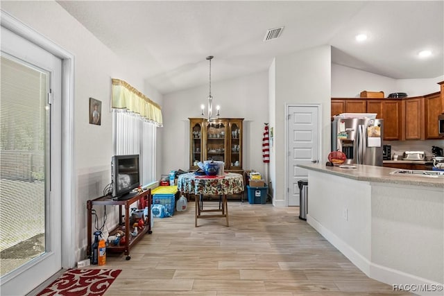kitchen with vaulted ceiling, light wood finished floors, stainless steel appliances, and visible vents