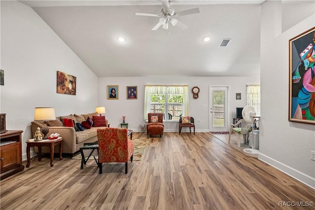 living room featuring light wood-style flooring, visible vents, high vaulted ceiling, and a ceiling fan