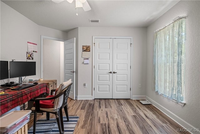 office with ceiling fan, baseboards, wood finished floors, and visible vents