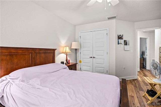 bedroom featuring baseboards, visible vents, a ceiling fan, wood finished floors, and a closet