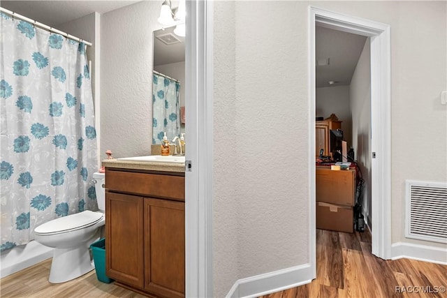 full bath with a textured wall, wood finished floors, visible vents, and toilet