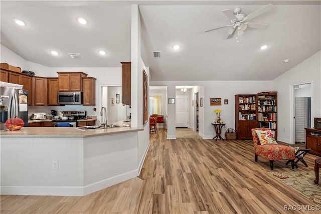 kitchen featuring vaulted ceiling, a ceiling fan, a sink, appliances with stainless steel finishes, and visible vents