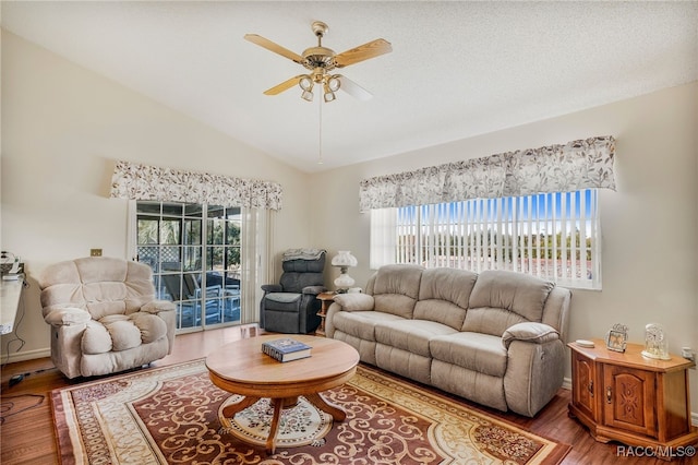 living room featuring a ceiling fan, lofted ceiling, a healthy amount of sunlight, and wood finished floors