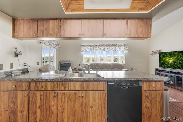 kitchen with brown cabinetry, dark countertops, black dishwasher, and open floor plan