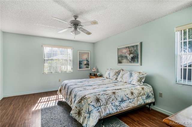 bedroom with multiple windows, dark wood finished floors, and baseboards