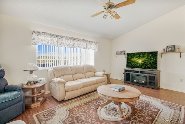 living room featuring lofted ceiling, baseboards, a ceiling fan, and wood finished floors