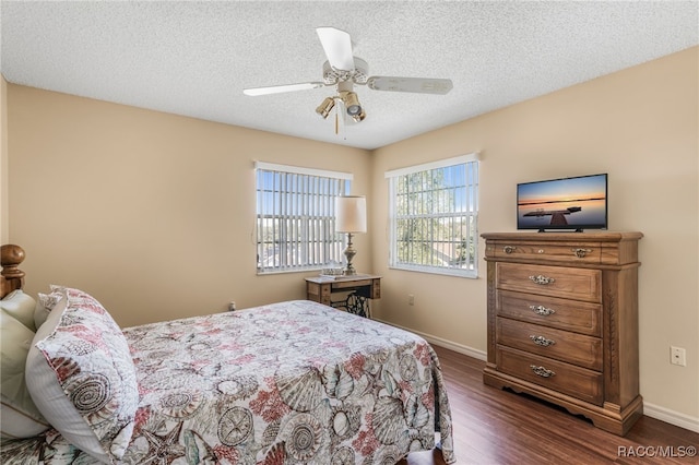 bedroom featuring dark wood-style floors, a textured ceiling, baseboards, and a ceiling fan