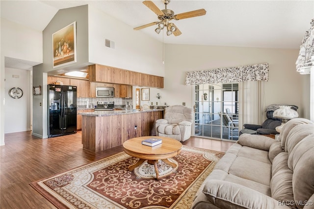 living area featuring high vaulted ceiling, dark wood-style floors, visible vents, and a ceiling fan