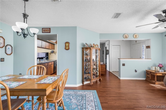 dining space with dark wood-style floors, baseboards, visible vents, and ceiling fan with notable chandelier