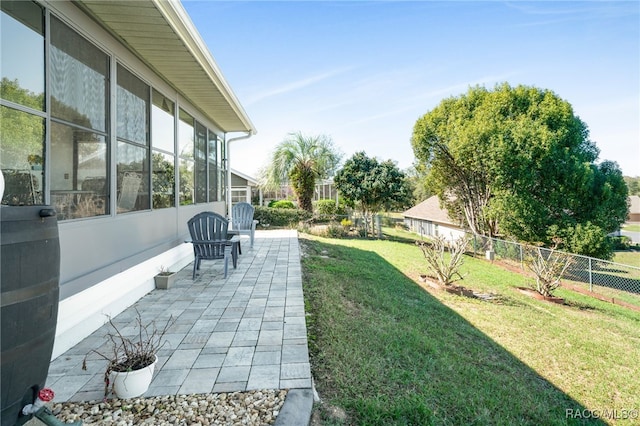 view of yard with a patio area, fence, and a sunroom