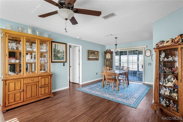 dining room featuring a textured ceiling, visible vents, dark wood-type flooring, and ceiling fan with notable chandelier