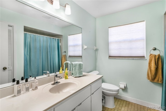 bathroom featuring toilet, vanity, baseboards, a closet, and tile patterned floors