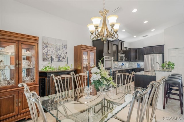 dining area with vaulted ceiling and a notable chandelier