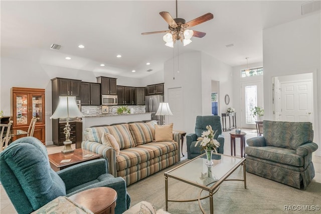 living room with a towering ceiling and ceiling fan