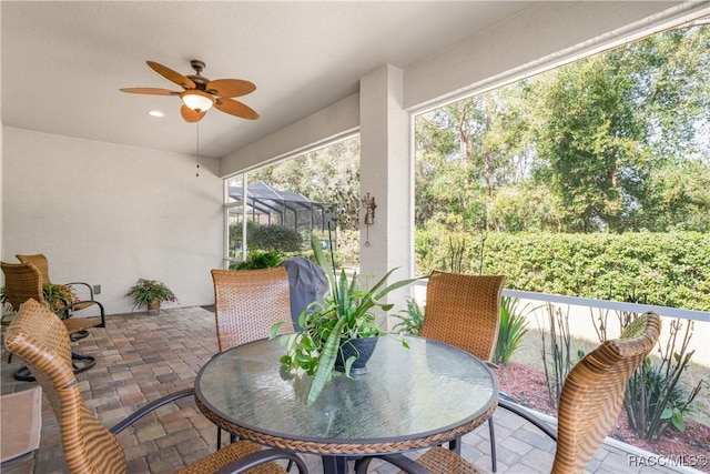 sunroom / solarium featuring ceiling fan