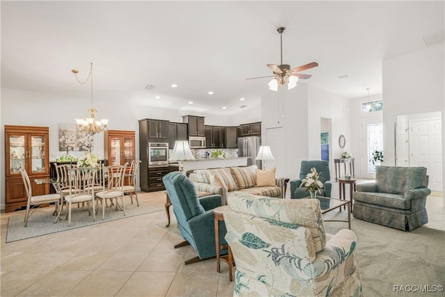 tiled living room featuring a towering ceiling and ceiling fan with notable chandelier