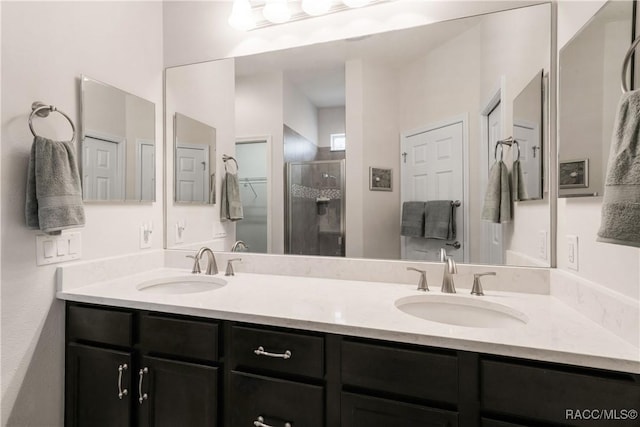 bathroom with vanity and a shower with door