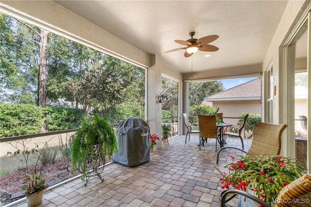 sunroom / solarium with plenty of natural light and ceiling fan