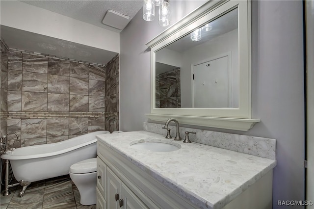 bathroom featuring toilet, a textured ceiling, a bathtub, and vanity