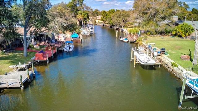 view of dock with a yard and a water view