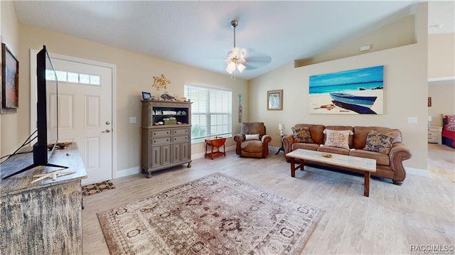 living room with ceiling fan, vaulted ceiling, and light wood-type flooring