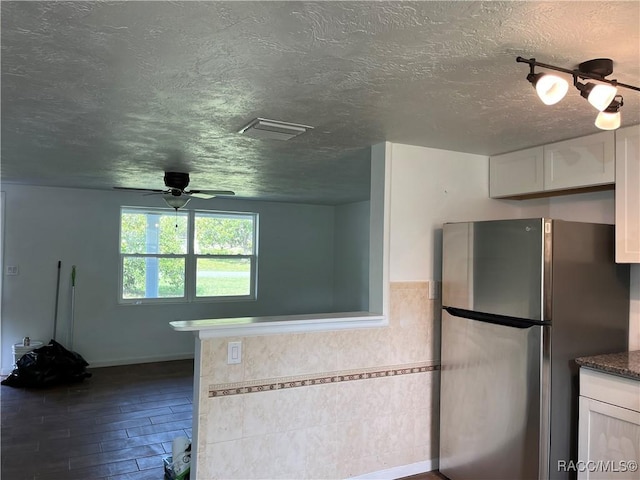 kitchen featuring white cabinetry, stainless steel fridge, dark hardwood / wood-style flooring, and ceiling fan