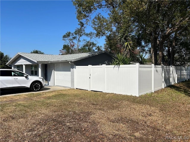 view of home's exterior featuring a garage and a lawn