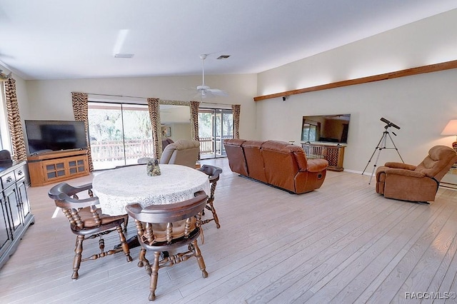 dining area with vaulted ceiling and light wood-style floors