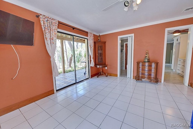 empty room with crown molding, visible vents, ceiling fan, and light tile patterned flooring