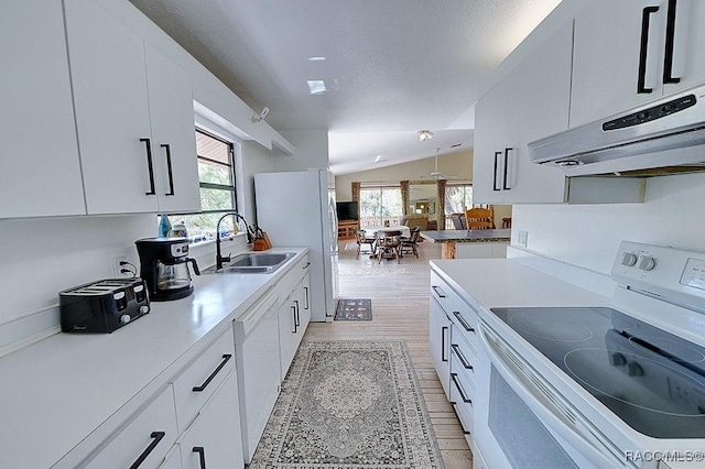 kitchen featuring white appliances, extractor fan, a sink, and white cabinets