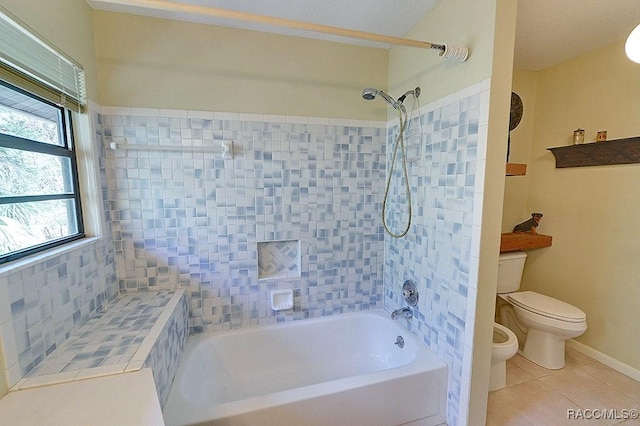 bathroom with toilet, bathtub / shower combination, baseboards, and tile patterned floors