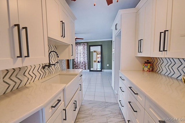 kitchen featuring a ceiling fan, marble finish floor, white cabinets, and tasteful backsplash