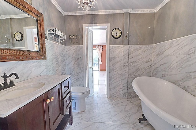 bathroom featuring ornamental molding, marble finish floor, a soaking tub, and vanity