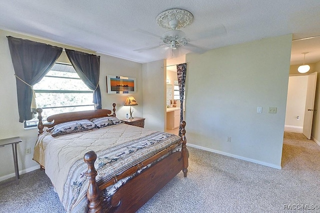 carpeted bedroom featuring ceiling fan, connected bathroom, baseboards, and a textured ceiling