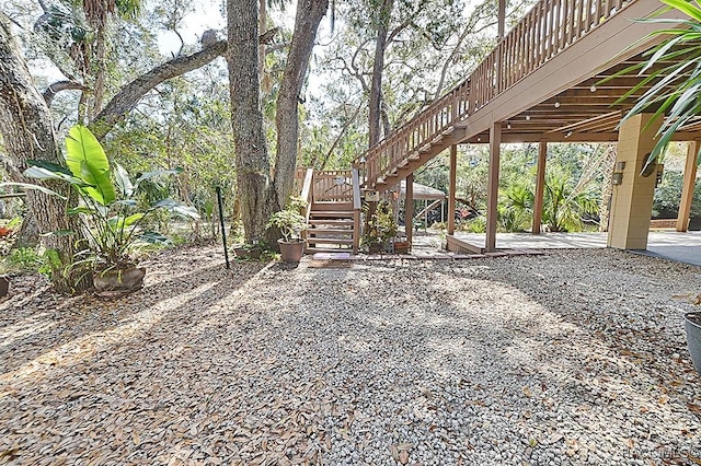 view of yard with a deck, a patio, and stairway