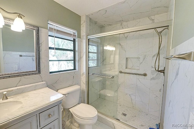 full bath featuring toilet, marble finish floor, a marble finish shower, and vanity