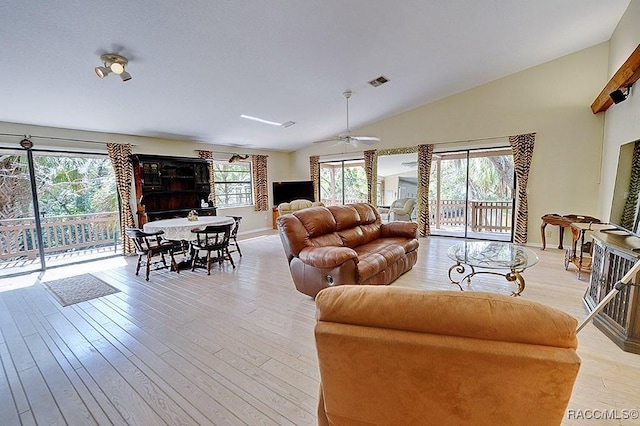 living area featuring light wood-style floors, plenty of natural light, visible vents, and ceiling fan