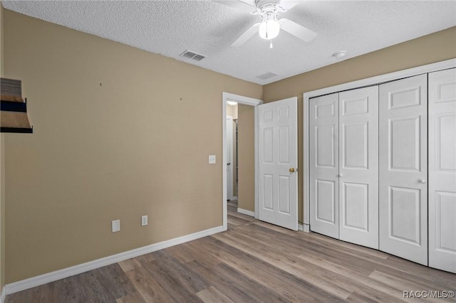 3224 E Davis Ln, Inverness, FL 34453 - unfurnished bedroom with wood finished floors, a textured ceiling, a closet, and a ceiling fan